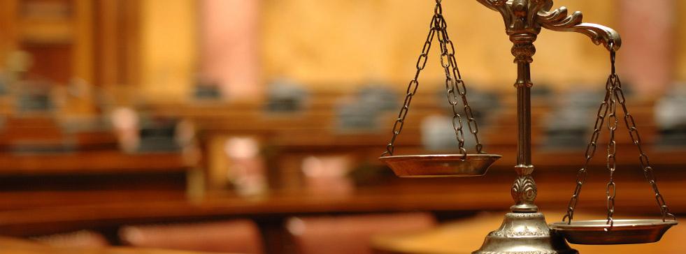Brass scales of justice on a courtroom bench